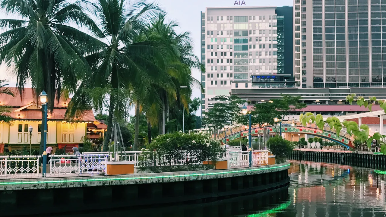 Evening scene along the Melaka River at Kampung Morten, with traditional Malay houses lining the waterfront